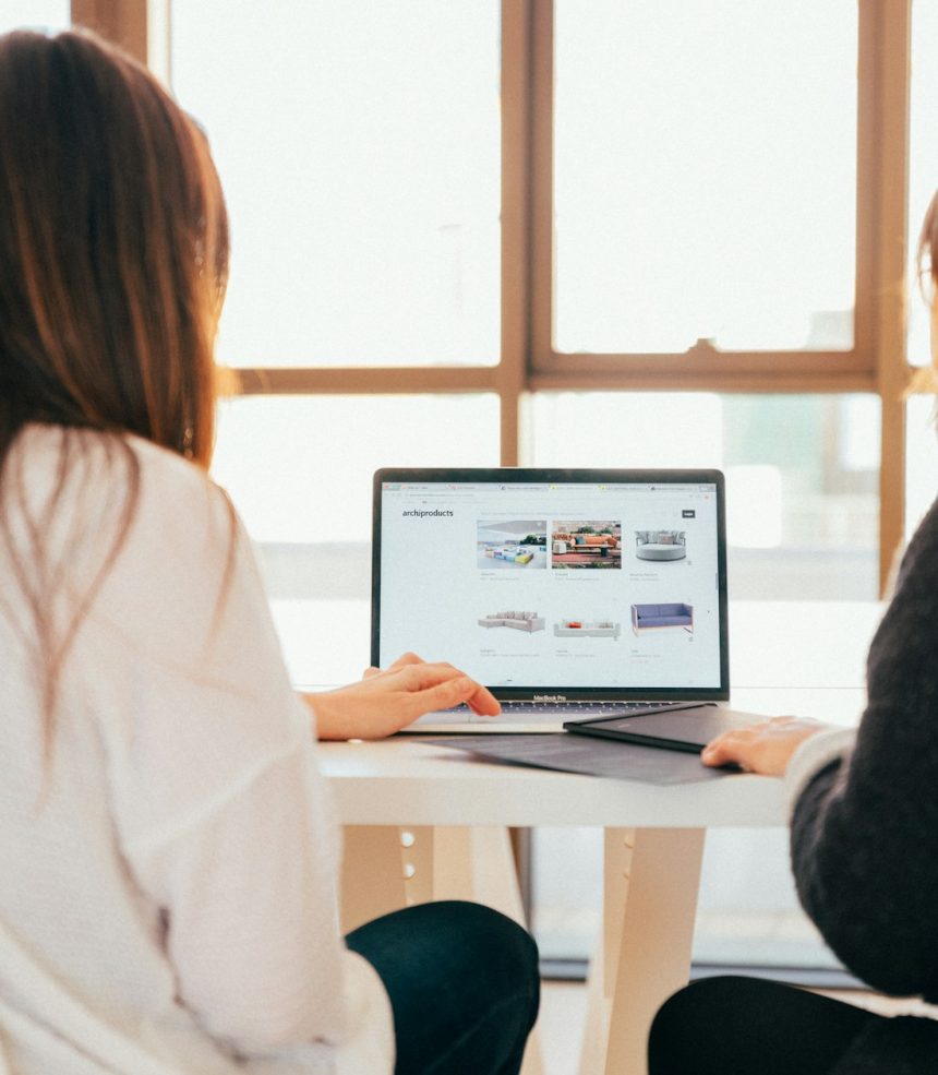Laptopta online mağazayı birlikte inceleyen iki kişi